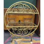 A gold painted wrought iron tea trolley, the circular scroll work sides with glass shelves between
