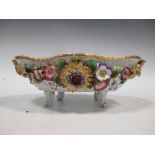 A Dresden floral encrusted porcelain fruit stand of shaped oval form with gilded border on scroll