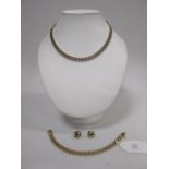 A 9ct three row brick link necklace, with concealed box clasp with safety catch, Sheffield import