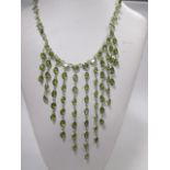 A peridot fringe necklace, the eleven graduating length drops of oval spectacle set peridots set