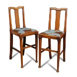 A pair of Aesthetic period mahogany music chairs, with drop-in seats raised on tapering
