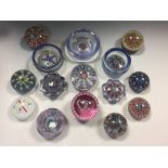 A collection of Scottish glass paperweights, including two spoke design dishes, a Scottish Borders