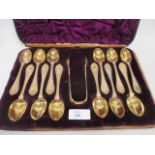 A cased set of 12 silver gilt tea spoons with tongs