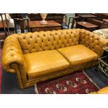 A pair of modern buttoned leather Chesterfield sofas, by Thomas Lloyd, finished in India yellow, (