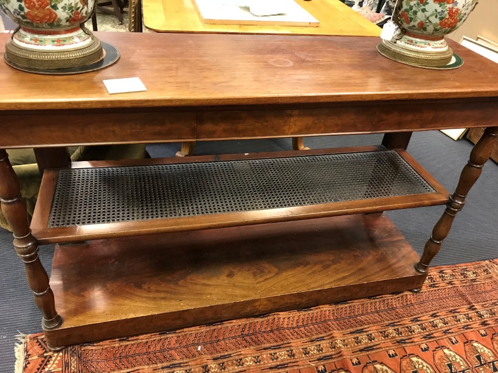 A Mid 19th century mahogany three tier buffet with caned second shelf, on turned column legs,