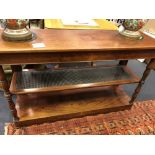 A Mid 19th century mahogany three tier buffet with caned second shelf, on turned column legs,