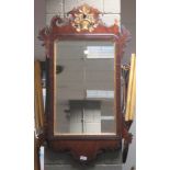 A Chippendale style wall mirror with fret carvings and gilded vase of flowers to the surmount