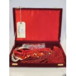 A quantity of coral and faux coral necklaces in a red velvet lined jewellery case