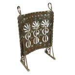 An Arts & Crafts copper fire screen, the curved panel with pierced and embossed decoaration to a