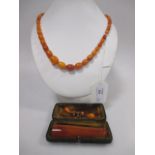 A butterscotch amber graduated bead necklace (some beads replaced with faux amber) together with a