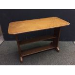 An Arts & Crafts oak low table, the rectangular top with canted corners raised on end supports and