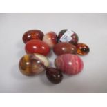 Seven red stone egg shaped hand coolers together with two of amber (9)