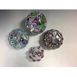Four John Deacons glass paperweights, comprising a scramble millefiori weight dated 1997, and