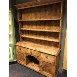 A Victorian pine dresser with 'dog kennel' base, carved decoration to the doors, 205cm h x 161w
