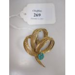 An 18ct turquoise set brooch, the three loops of twisted, reeded and banded gold set with a small