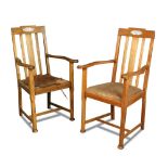 A pair of Arts & Crafts oak elbow chairs, the backs with mother-of-pearl inlaid cartouche above