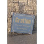 A double sided advertising sign on a metal wall bracket, promoting Gratton Chartered Surveyors and