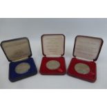 Three cased commemorative Royal British Legion medallions.