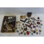 A box of assorted WWI and later military regimental badges including world, cloth and officers