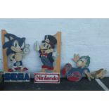 Four wooden cut out characters including a Nintendo Super Mario Sega Sonic etc.