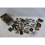 A box of assorted cloth military badges including Army, Navy and R.A.F.