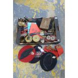 A box of assorted militaria including various berets, WWI trench art, knives, shrapnel, gas masks