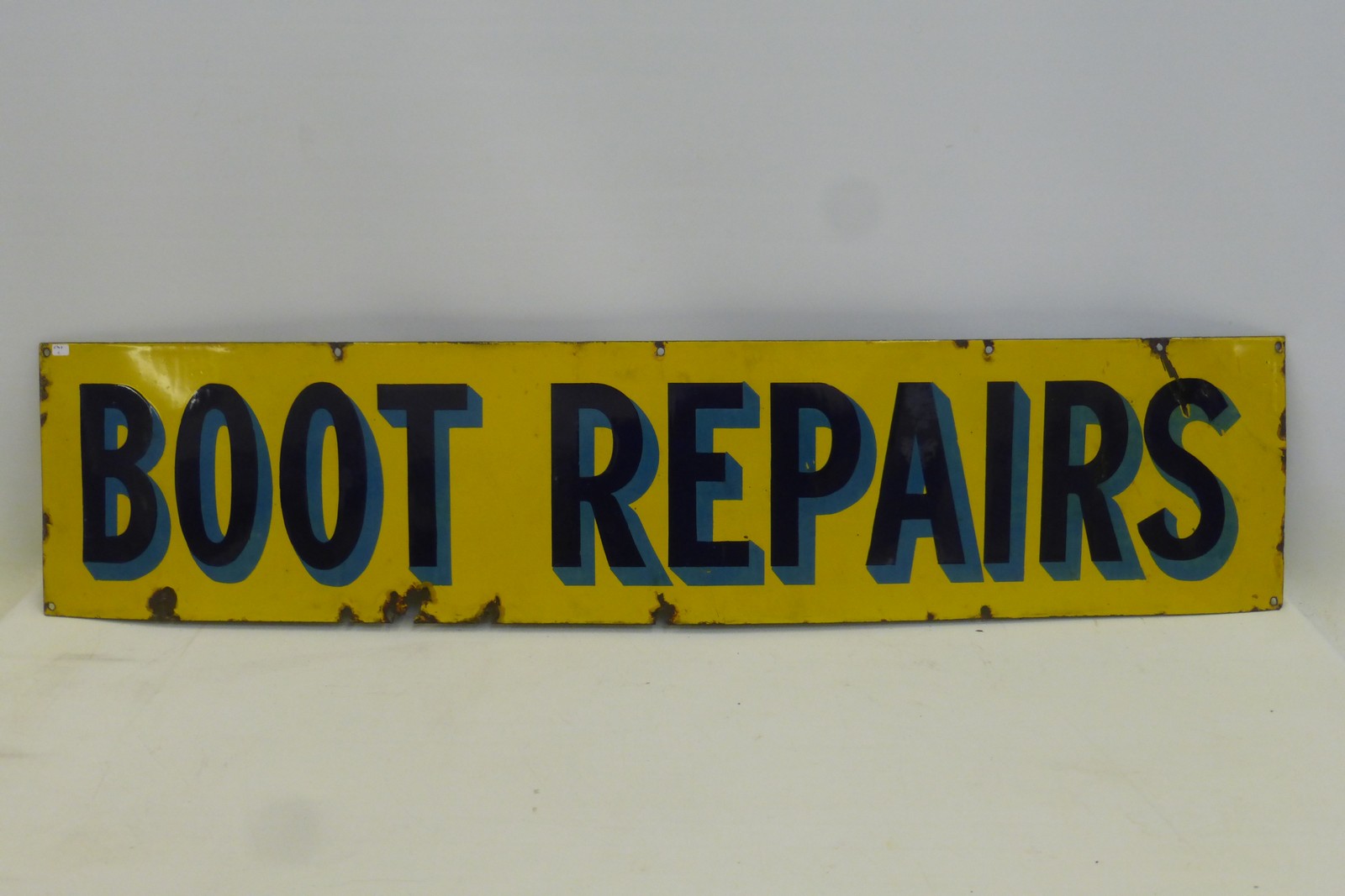 A rectangular blue and yellow enamel sign "Boot Repairs", with good gloss, 46 3/4 x 10 1/4".