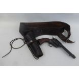 A replica Colt 45 pistol (BB) and a leather holster, in good condition.