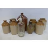 An assortment of stoneware storage jars and flagons, three inscribed Henly's Stores, Calne; also