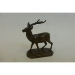 A bronzed figure of a standing stag.