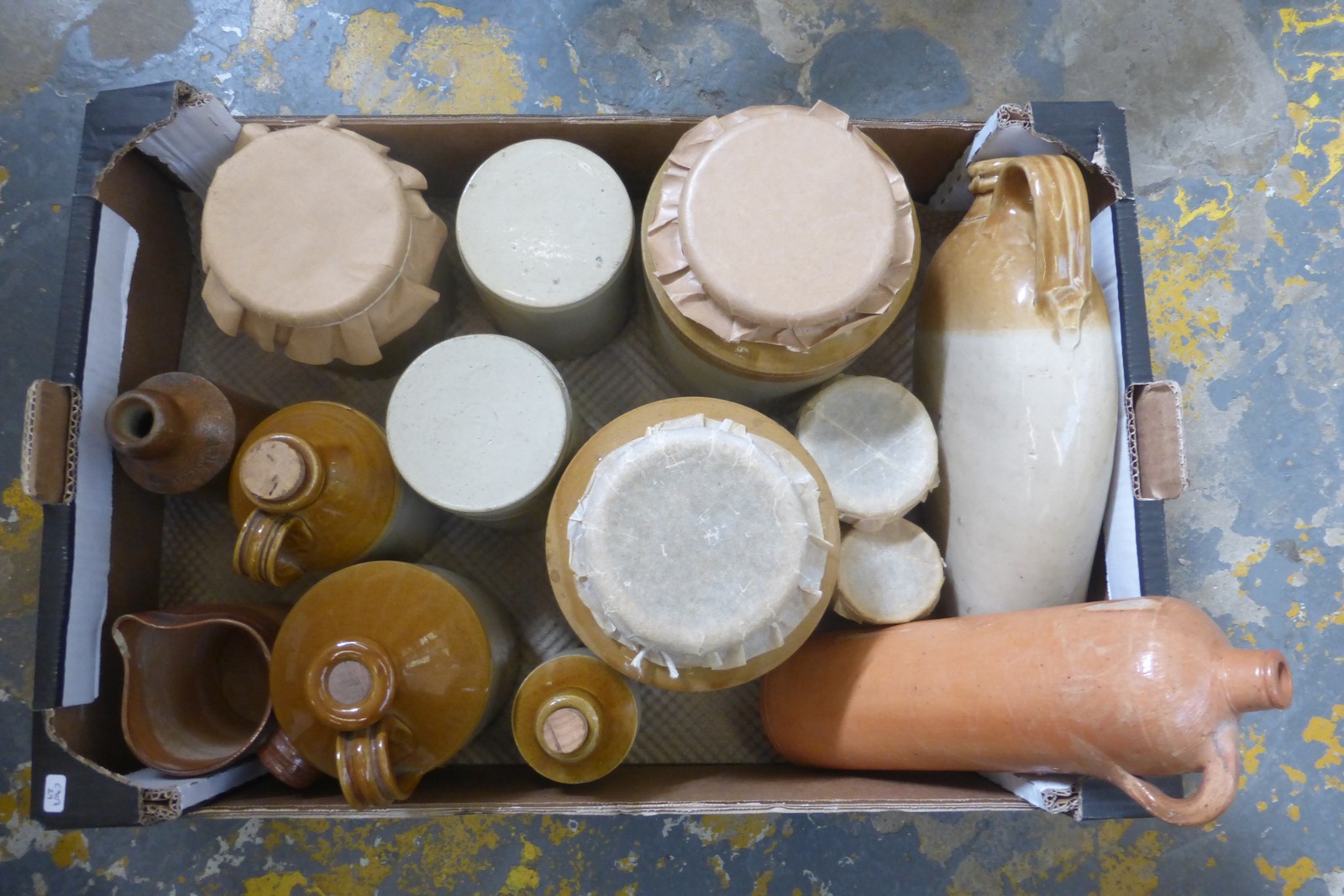 An assortment of stoneware jars, flagons, and two ginger beer bottles marked H. Merry and Maskell