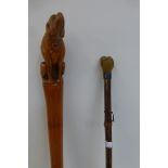 A walking stick with the knopp carved in the form of a seated dog and a walking cane with a knopp in