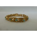 A Middle Eastern gold and turquoise set bracelet of unusual form.