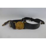 An early 20th Century Royal Navy sword belt with gilt buckle and hanging straps.