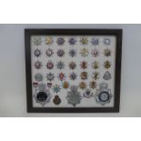 A framed display of thirty-nine fire brigade and police badges.