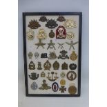 A framed display of 39 assorted military badges.