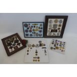 Five framed displays of assorted badges and buttons including military.