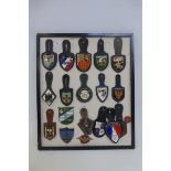 A framed display of eighteen French military badges.