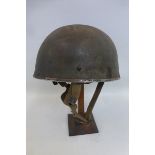 A 1955 British Paratrooper's helmet with liner and chin strap.