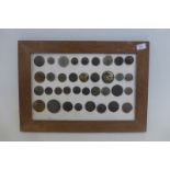 A framed display of metal detector finds of thirty-six military buttons.