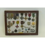 A glazed display of Third Reich medals and insignia.