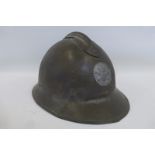 A French Adrian helmet with original liner and chin strap.