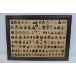 An oak framed display of 127 British military cap badges.