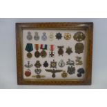 A framed display of twenty-eight military medals, badges and police badges.