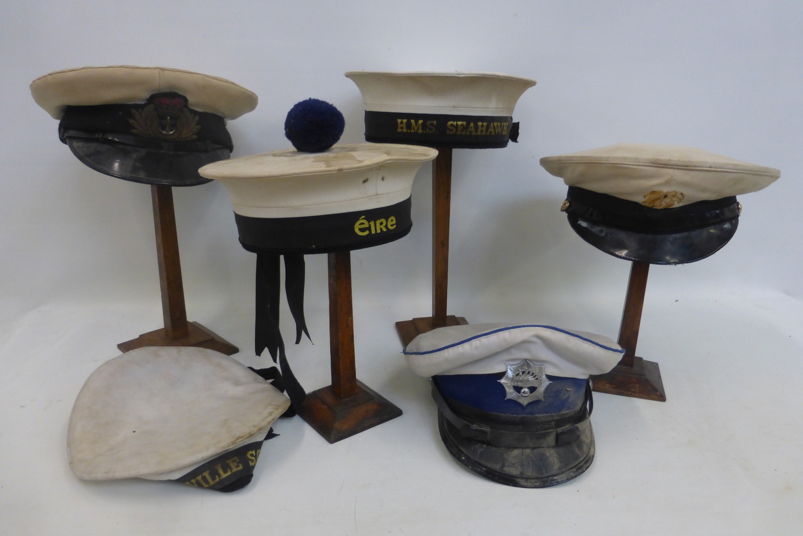 A box of six naval caps and hats.