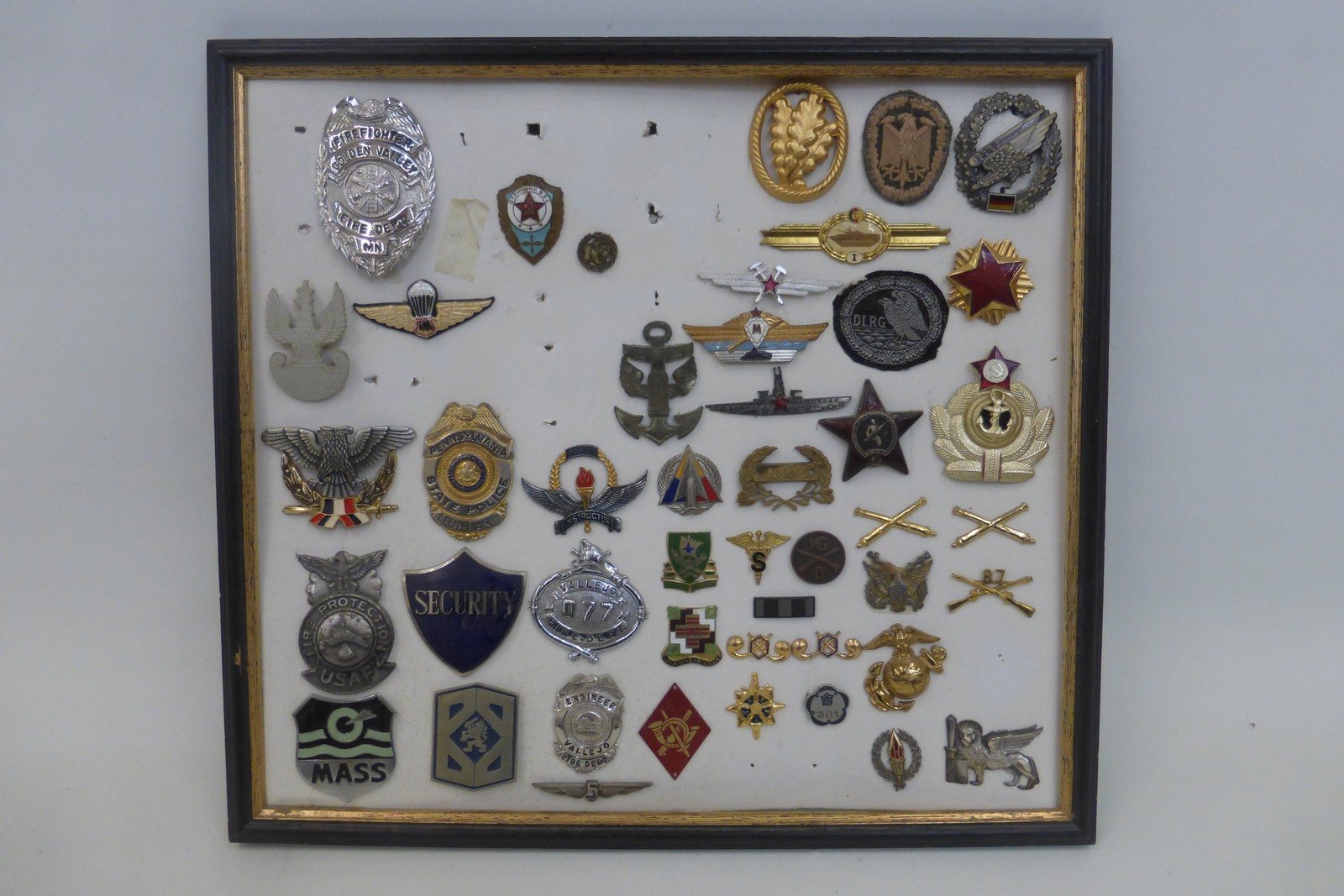 A framed display of assorted military and police badges.
