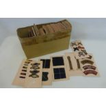 A box of military cloth trade badges, rank insignia and shoulder flashes attached to card (