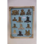 A framed display of 12 British military cap badges.