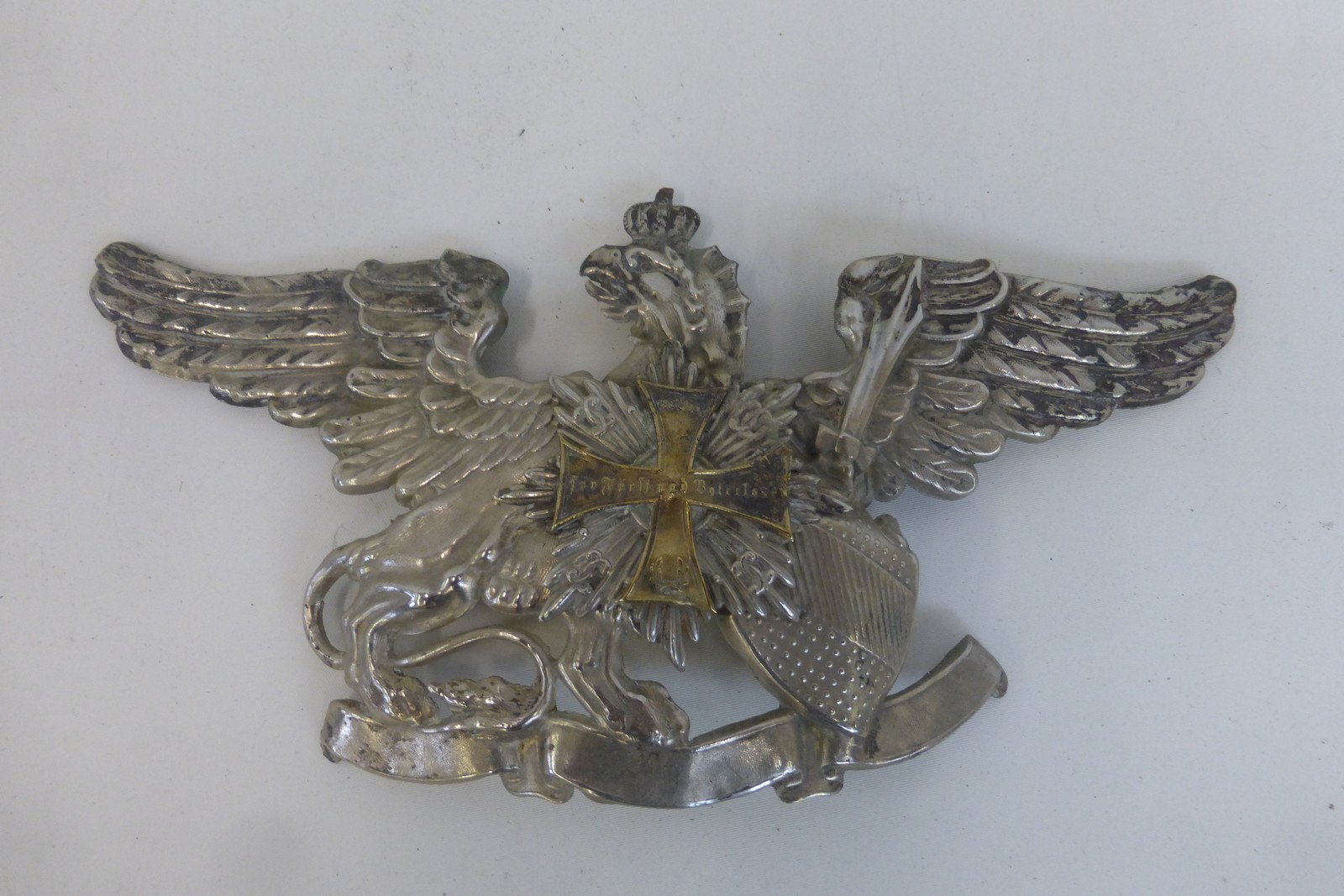 A white metal Imperial German helmet plate.