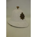 A Royal Marines pith helmet with brass and enamel badge.